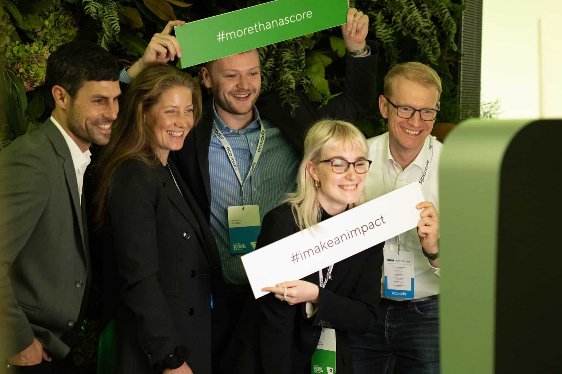 Freudige Gruppe posiert mit Textschildern vor Fotobox von formwandler events